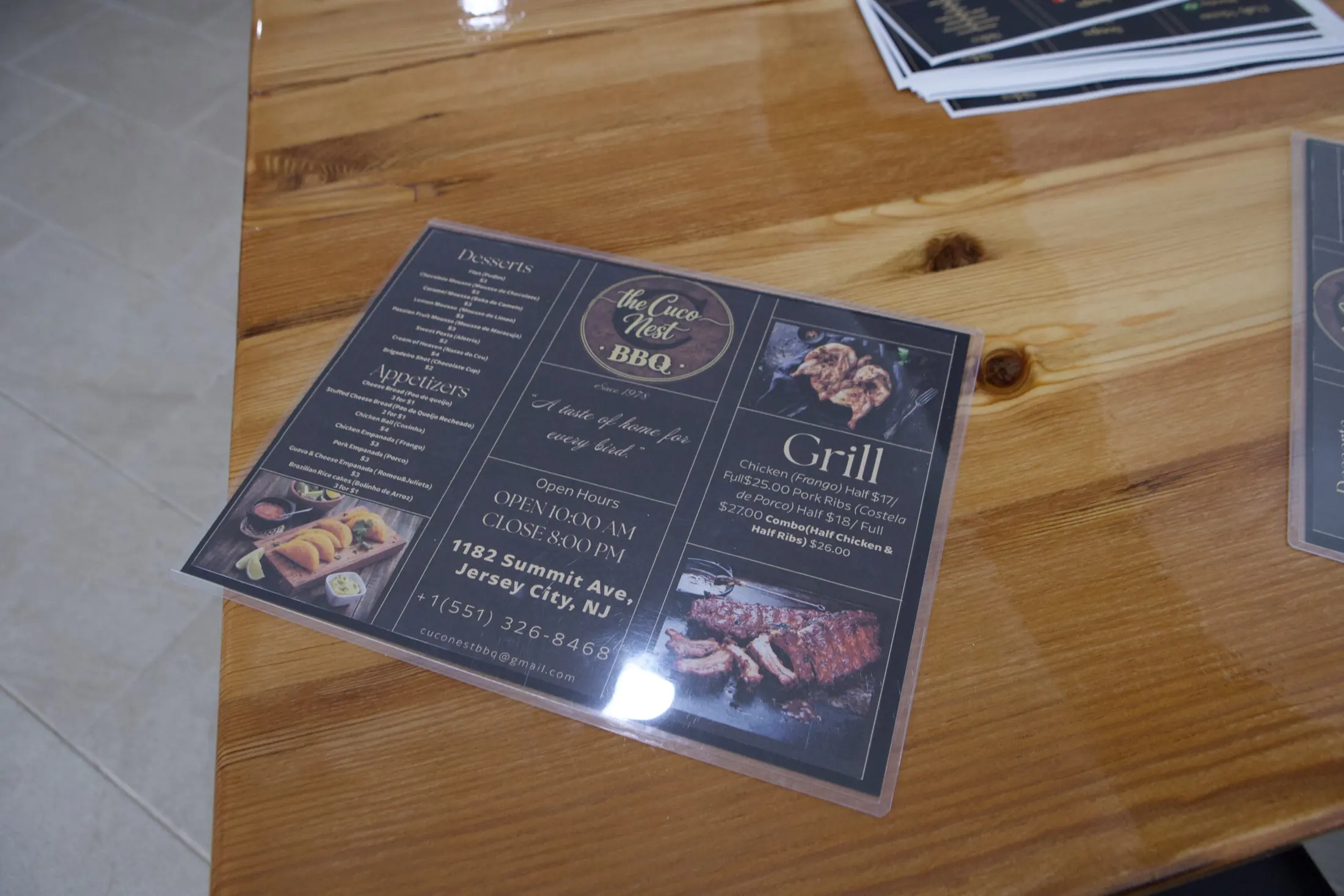 The Cuco Nest BBQ printed menu on a wood table